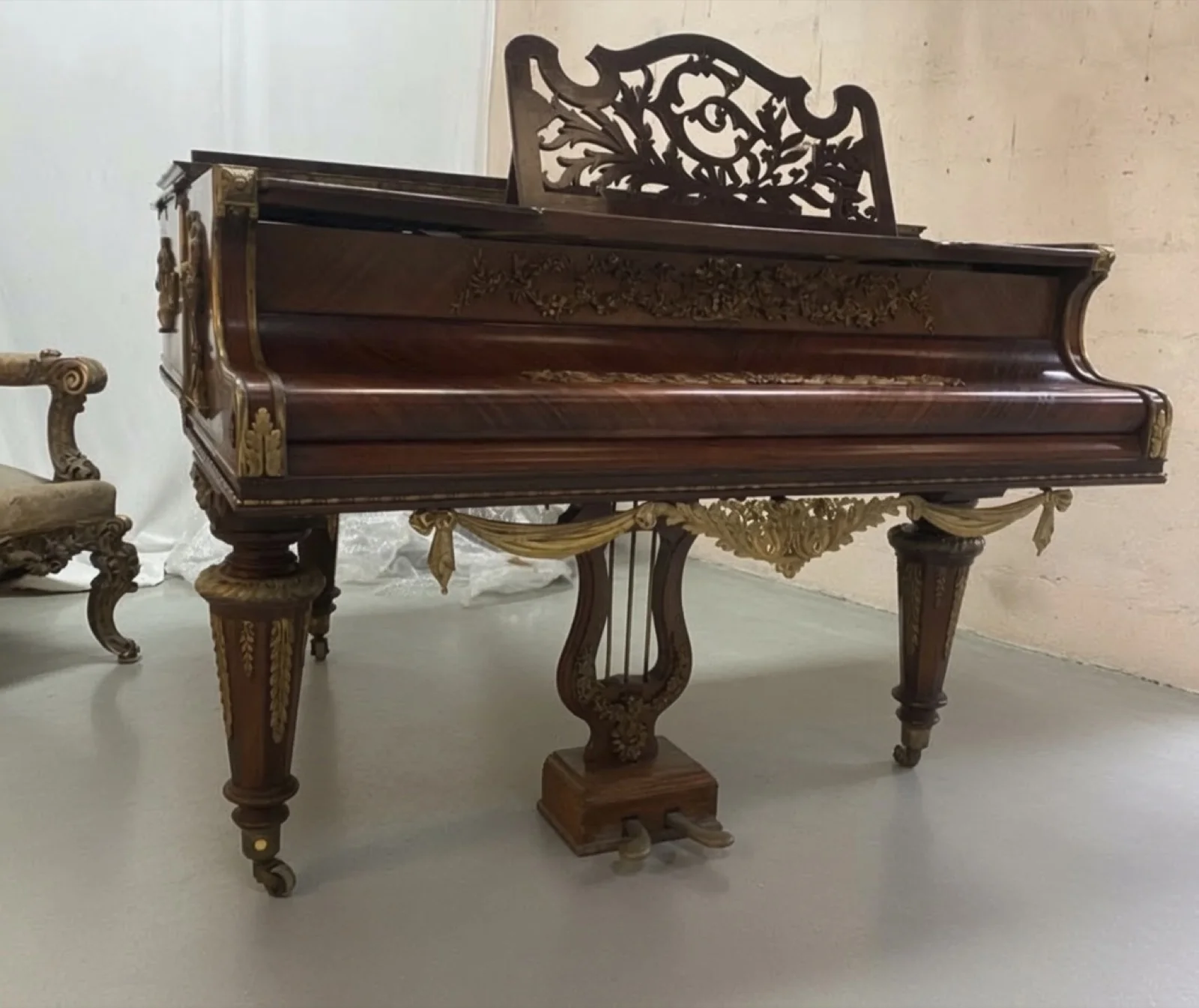 An ornate antique rosewood grand piano with gilt mounts