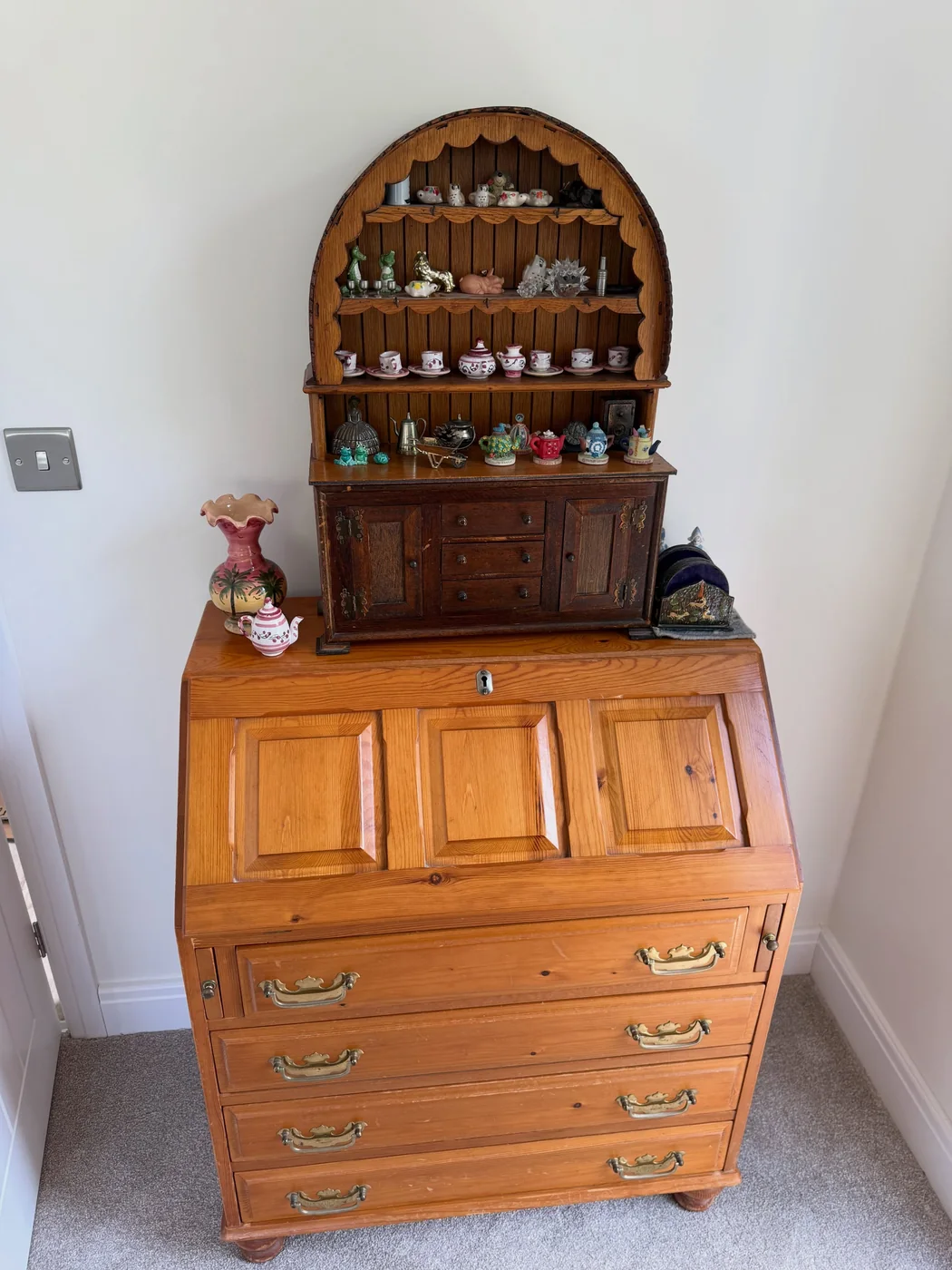 Antique pine bureau in place with a miniature dresser and china collection set out on it