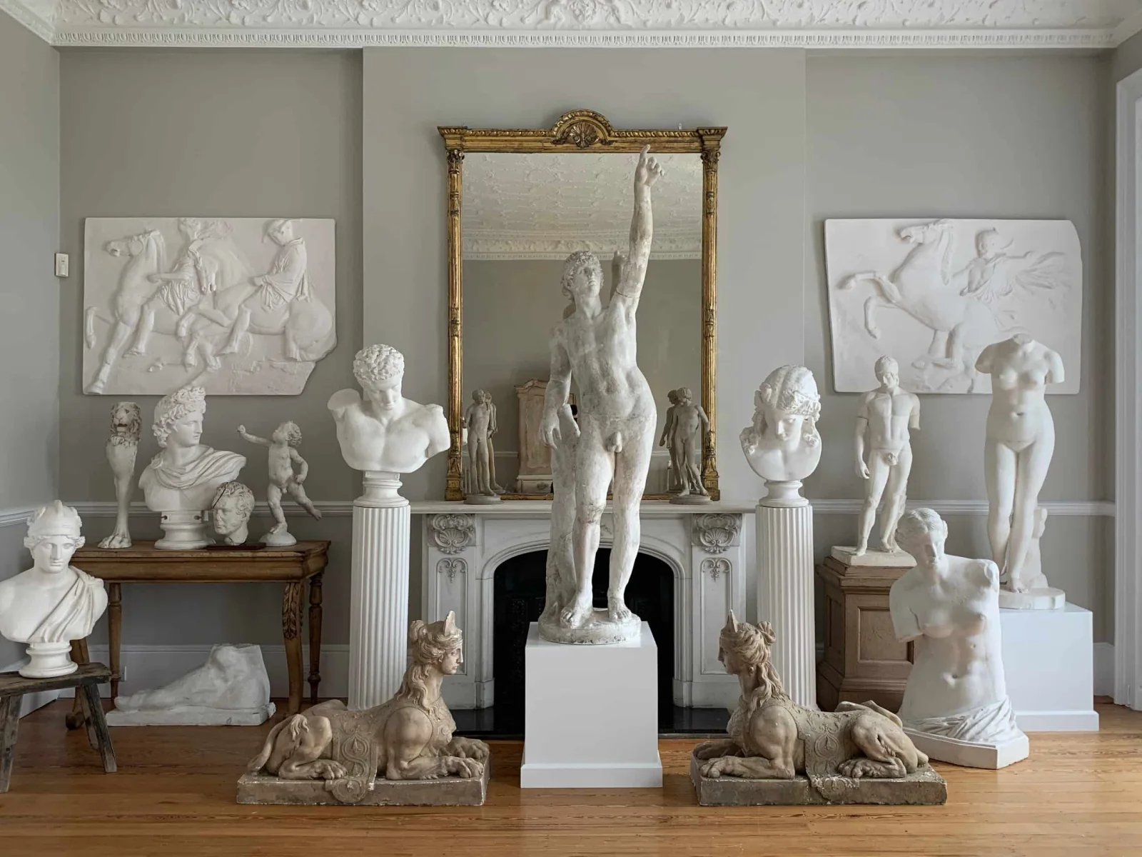 Classical marble busts, statuary and a gilt overmantel mirror in a West Sussex period drawing room