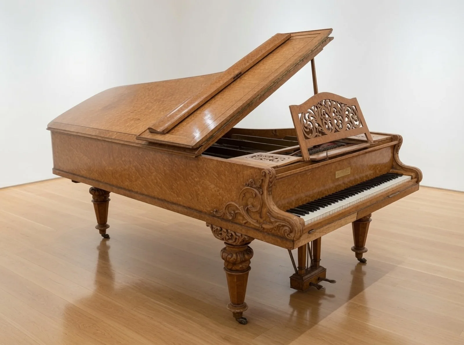 An antique birds-eye maple grand piano on a wooden floor