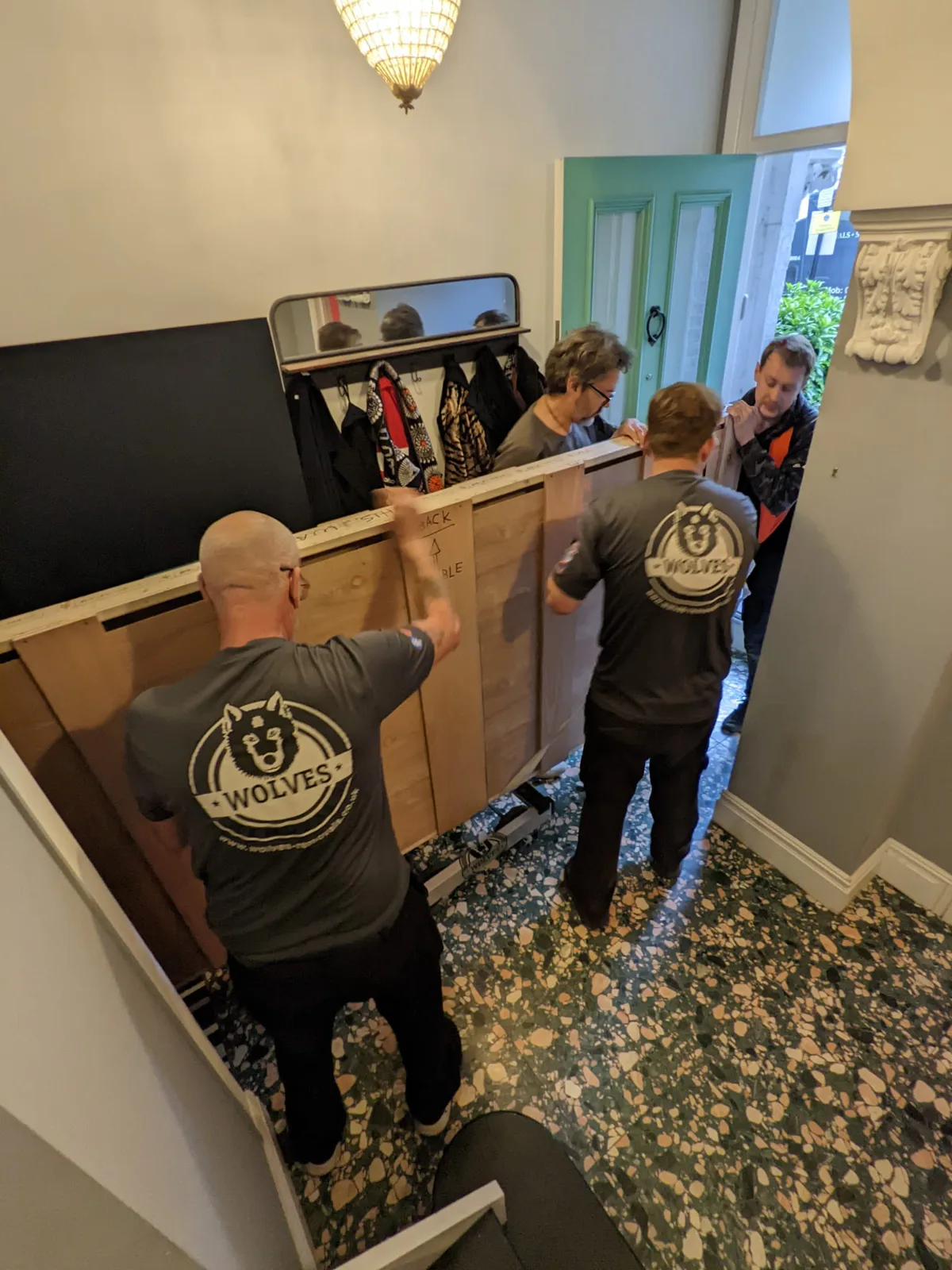 Crew carrying wooden crates through a room