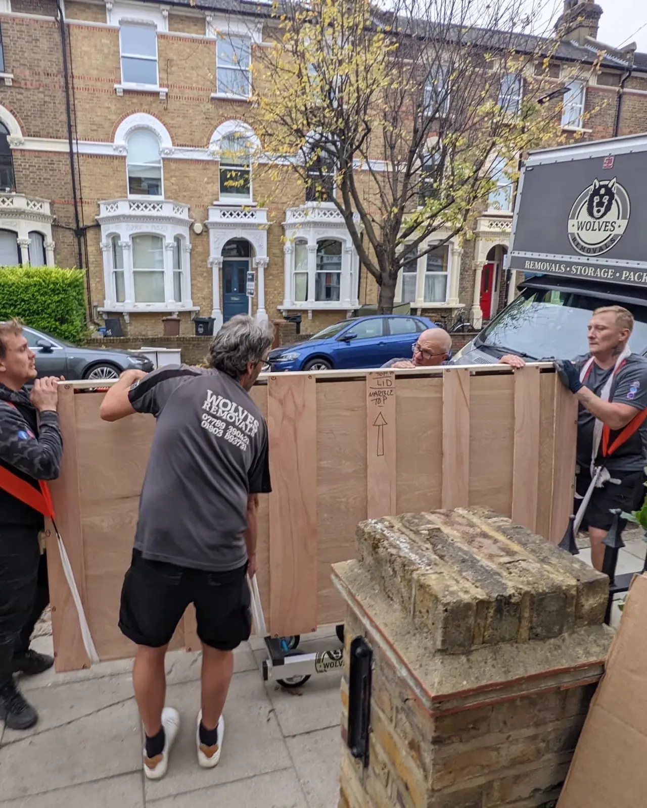 Carrying export crate outside townhouse