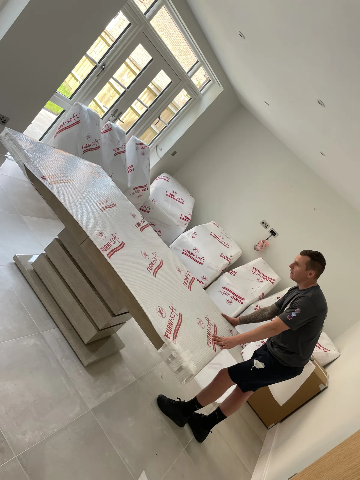Crew with wrapped furniture in a modern room