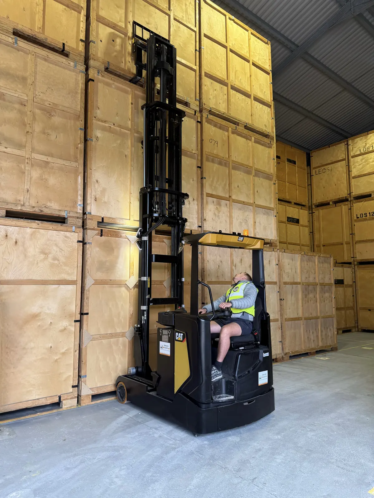 A forklift lifting a storage crate at the Wolves Removals store