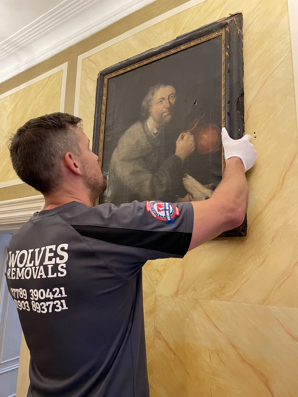 Crew carefully handling a framed old-master for a move in Kent