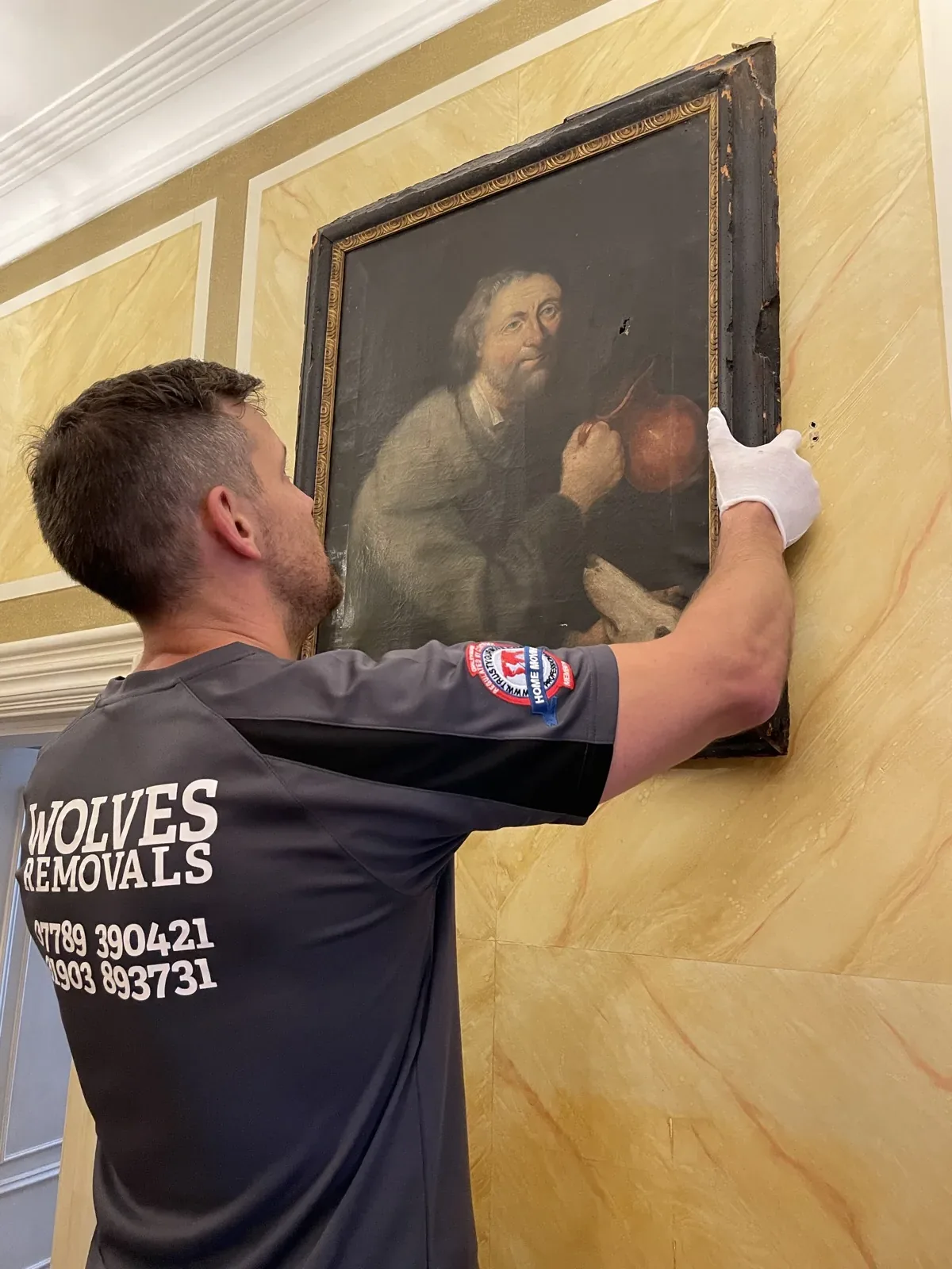 Hanging an antique oil portrait on the wall on a Horley house move