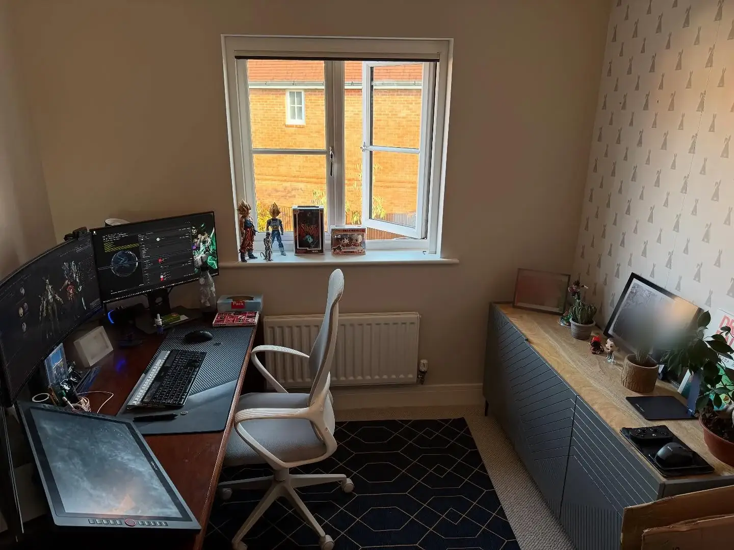 A home office rebuilt after a move, with monitors, a drawing tablet and a sideboard set back up