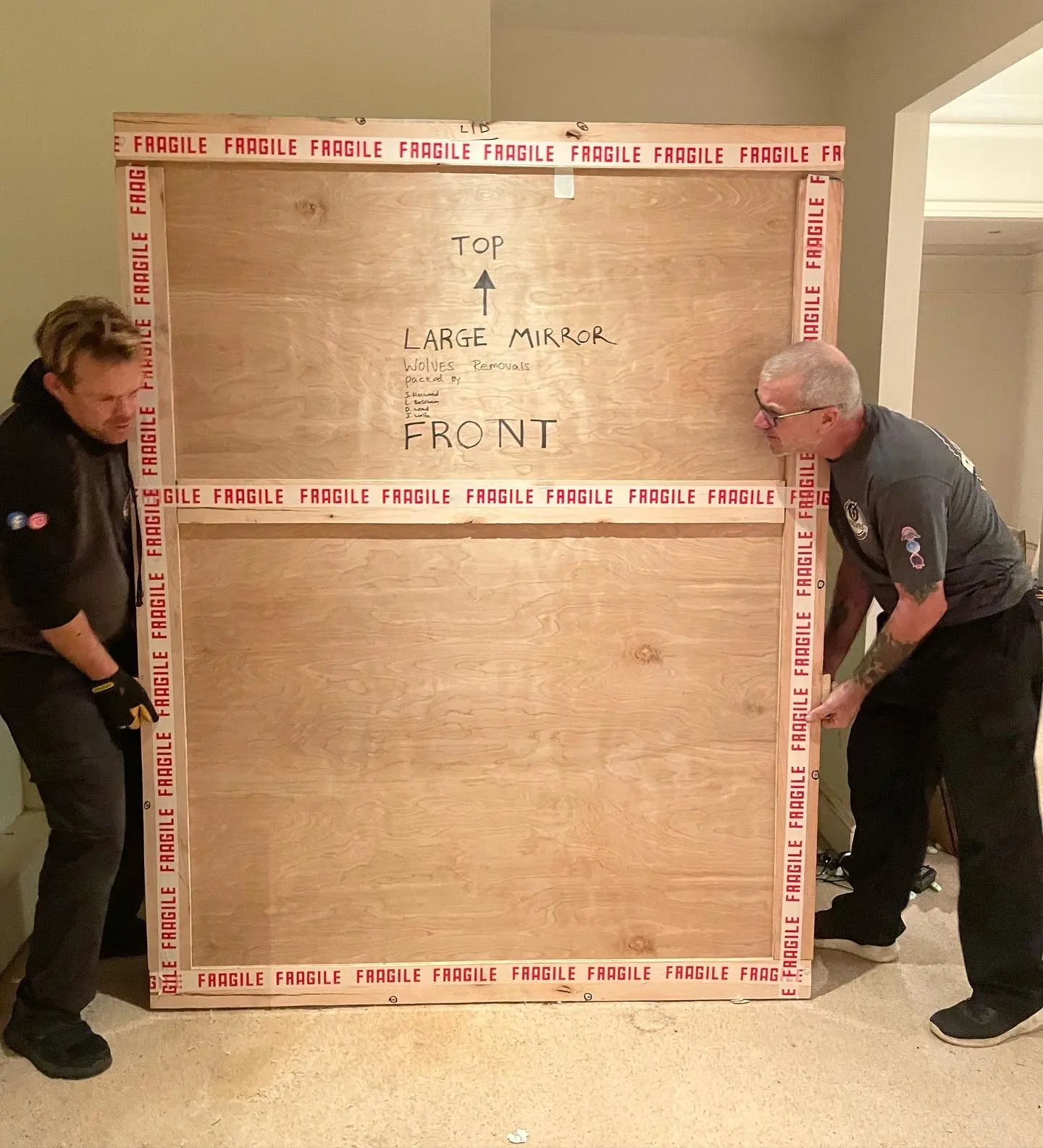 Crew with a large 'antique' wooden crate in a room