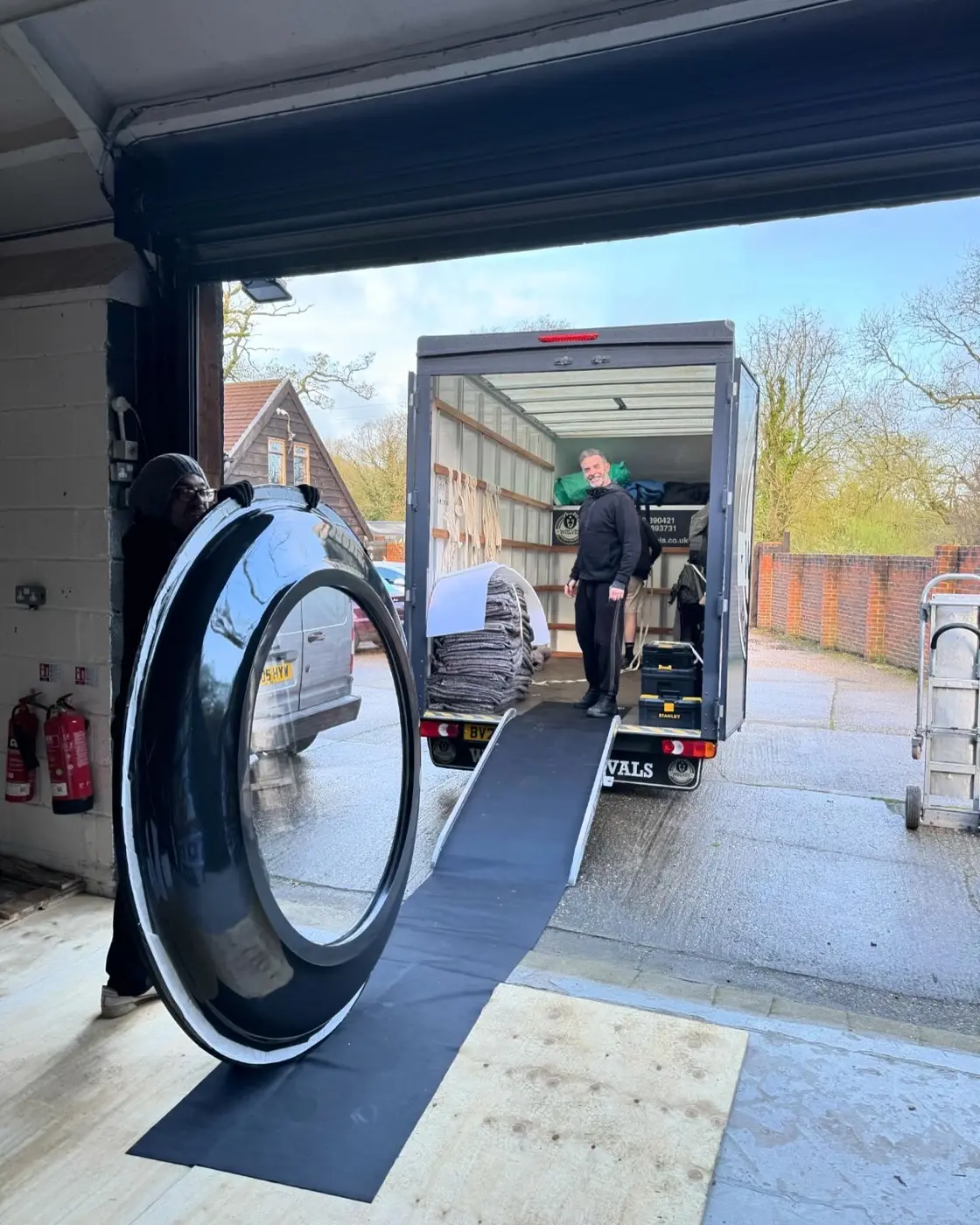 Loading a large round mirror into a Wolves Removals van