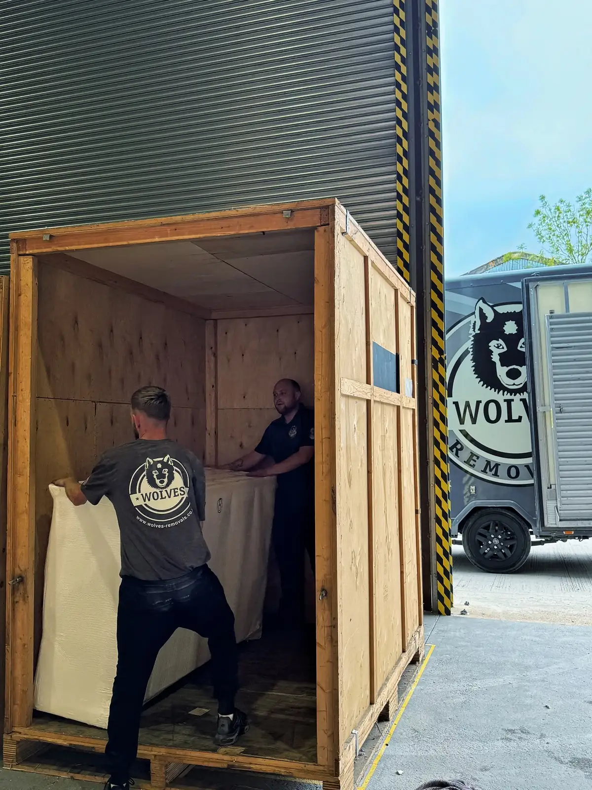Loading a wooden crate into the lorry for a move in Redhill, Surrey