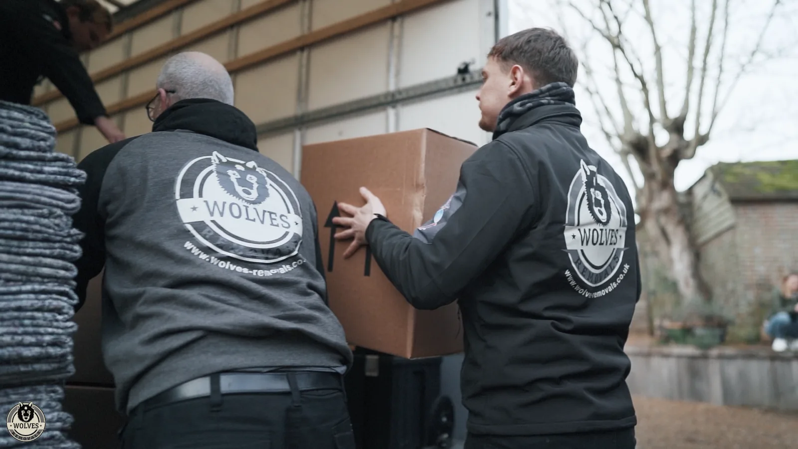 Movers taping a cardboard box during packing