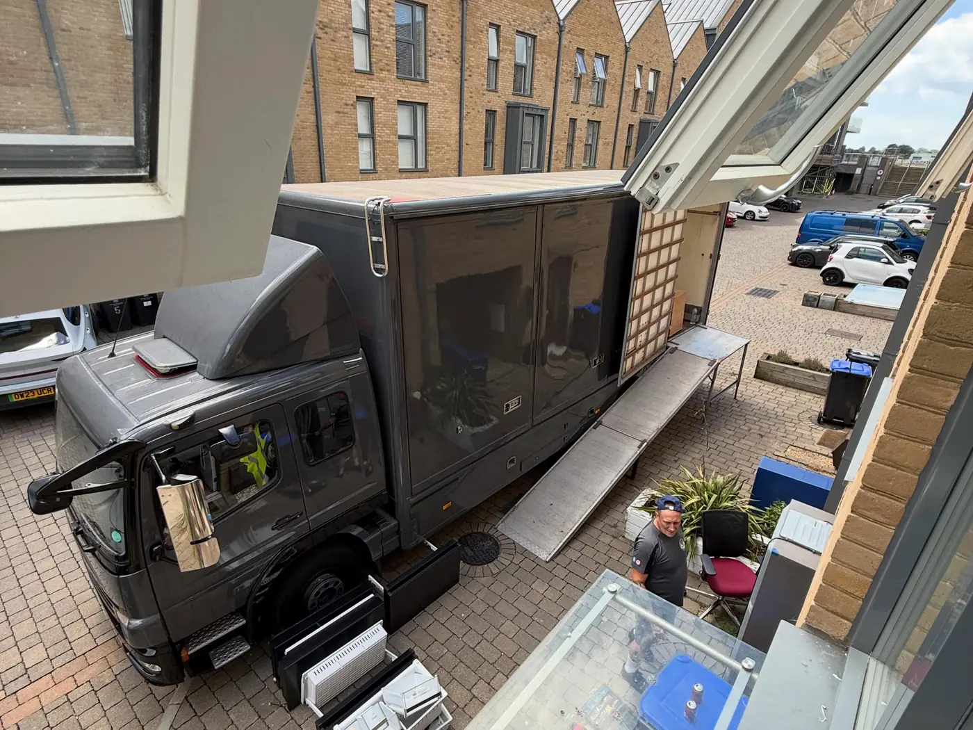 Wolves Removals lorry with its ramp down in a courtyard of modern brick townhouses