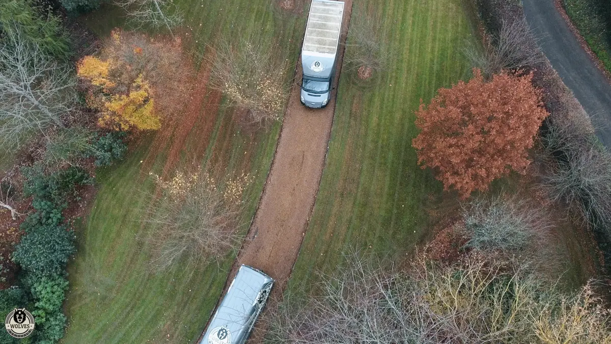 Aerial view of removals vans at a rural property in autumn