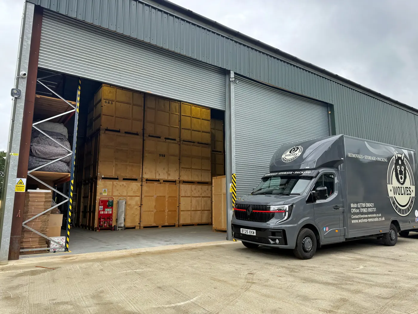 A van at the storage depot with tall crates on a Cranleigh house move