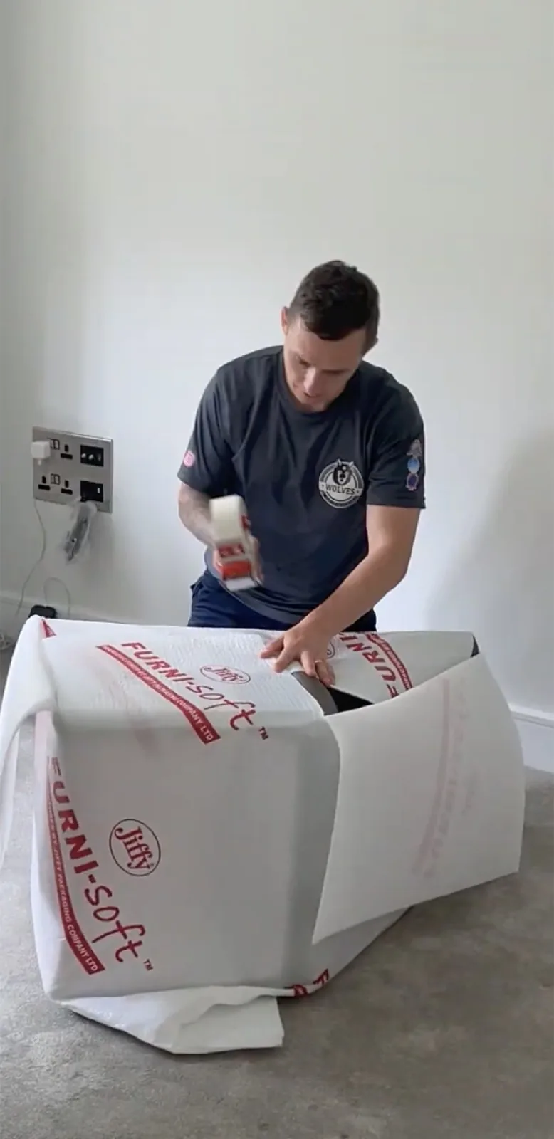 Taping Furni-Soft padding around a furniture item for a move in Kent