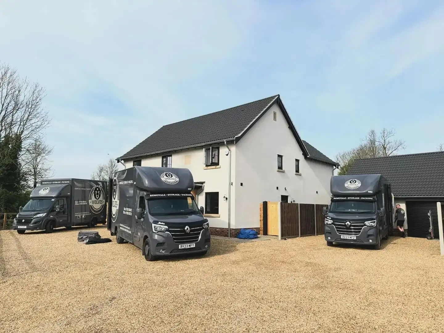 Three Wolves Removals Luton vans parked on gravel outside a rendered house at Bushy Common near Dereham, Norfolk