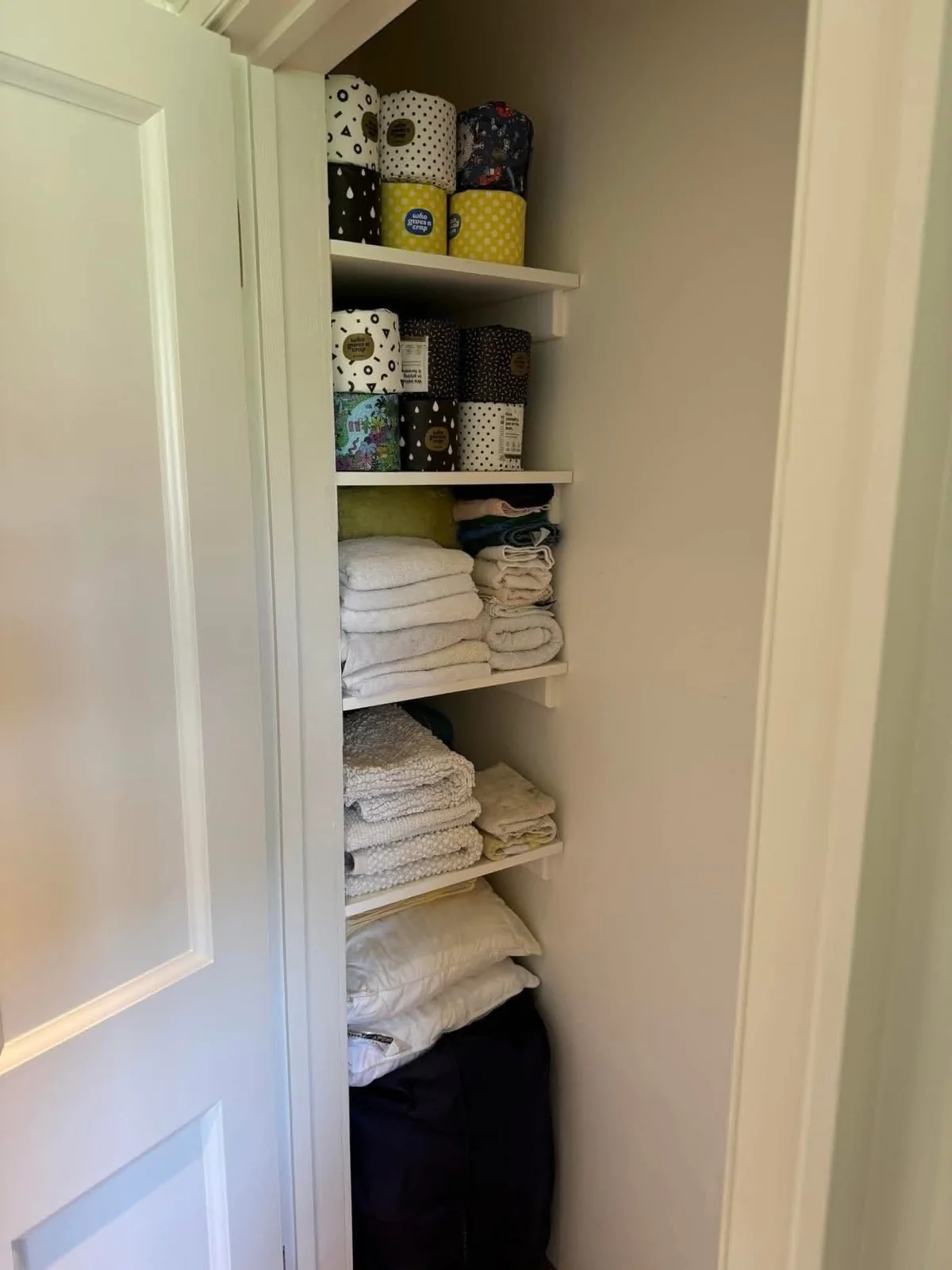 Linens and towels unpacked and folded onto closet shelves after a house move