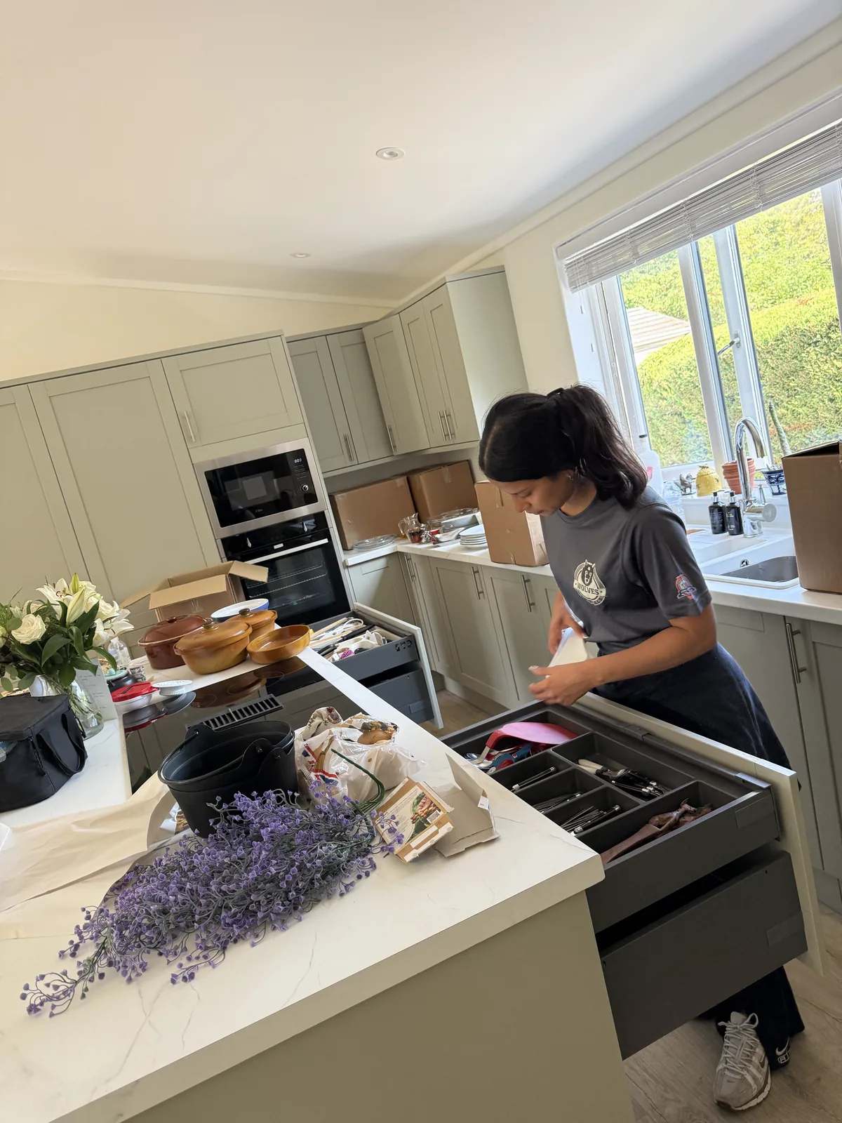 A Wolves Removals crew member unpacking cutlery into a kitchen drawer
