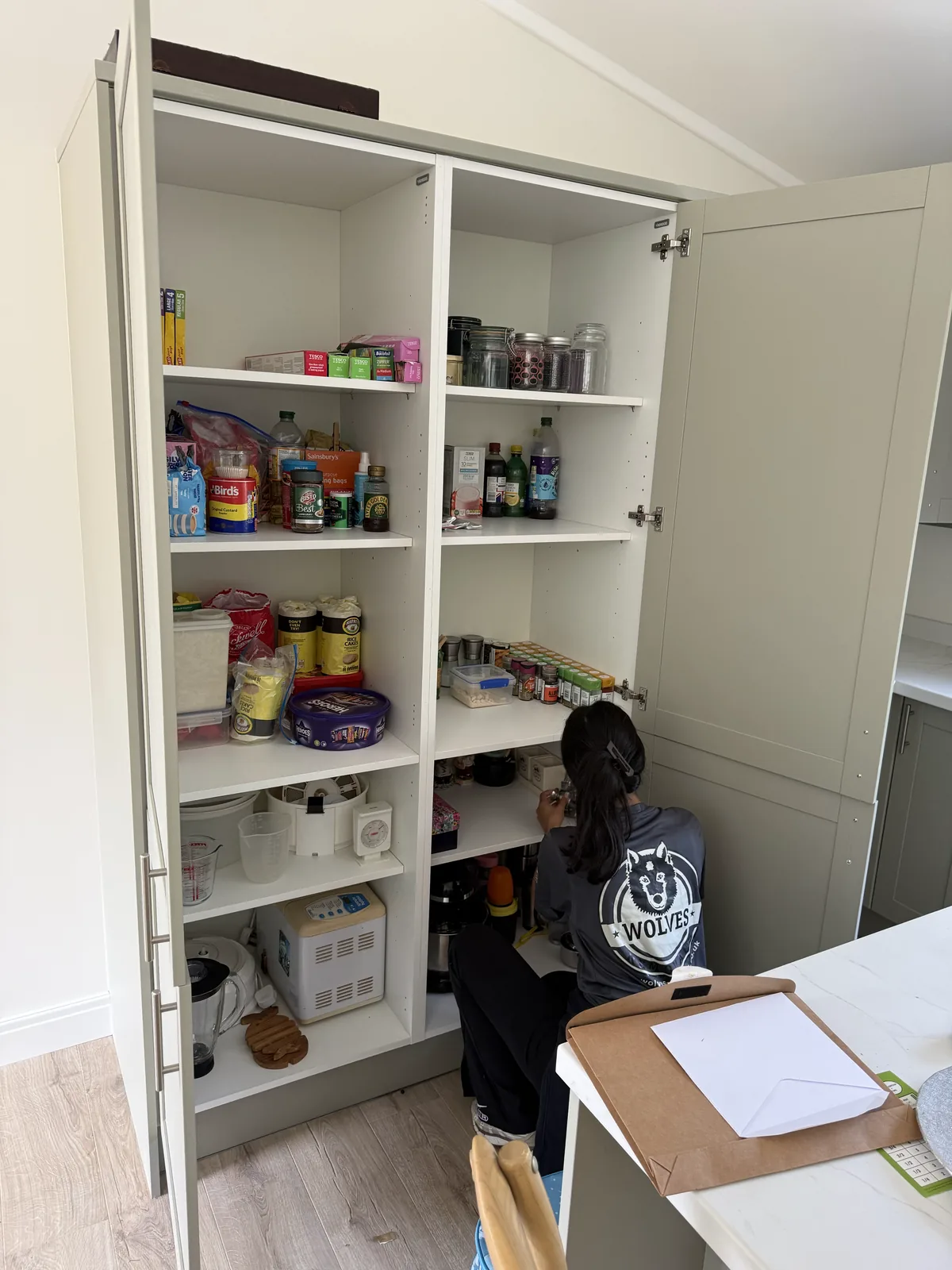 A Wolves Removals crew member filling a kitchen larder cupboard during a full unpack