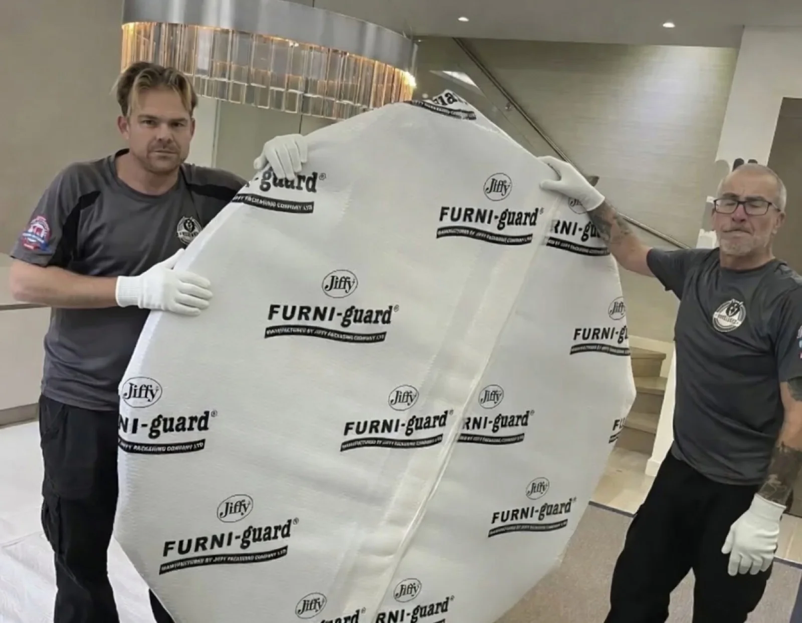 Wolves Removals crew in white gloves carrying an item wrapped in protective padding