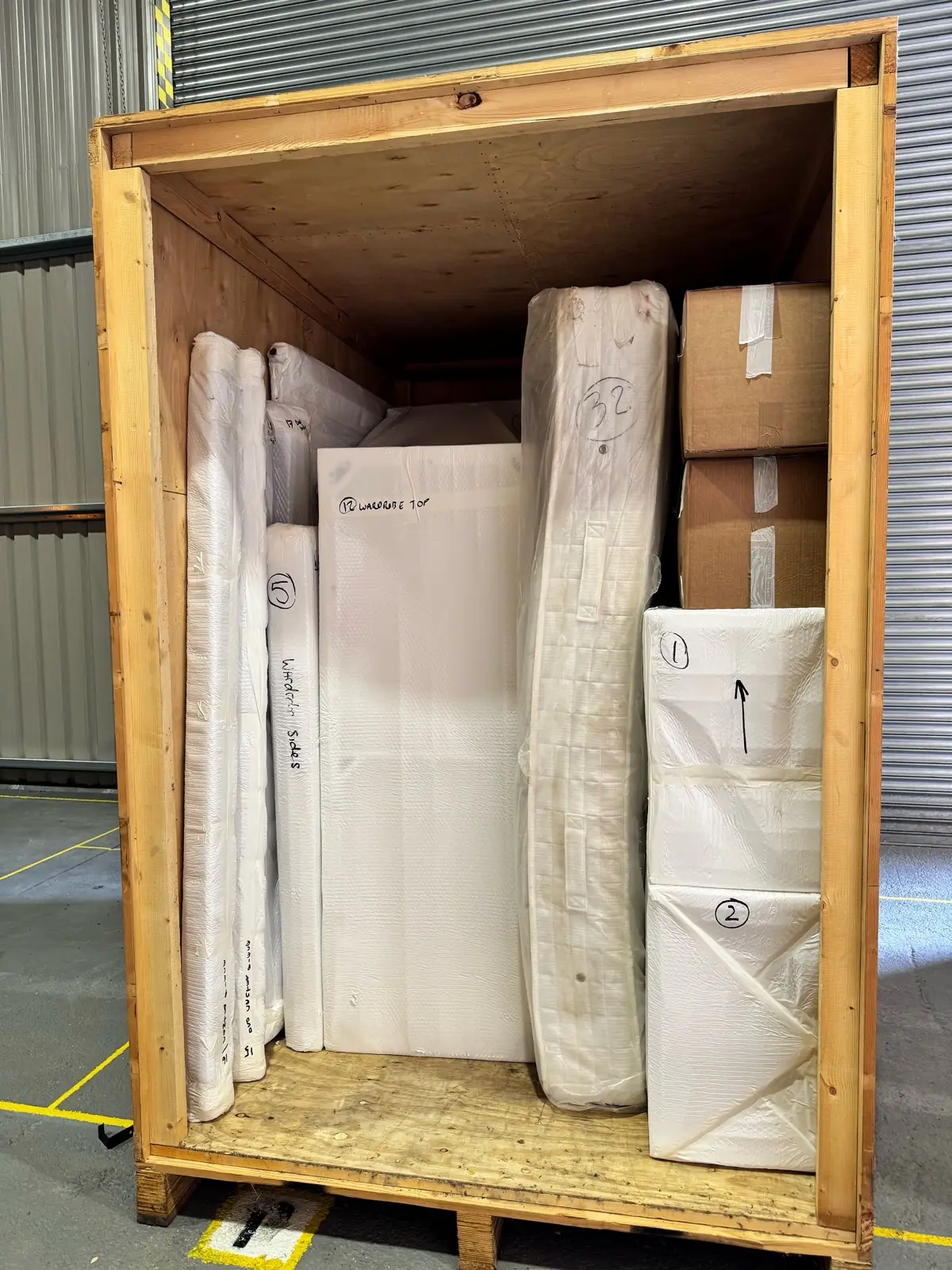 A wooden crate packed with wrapped antiques