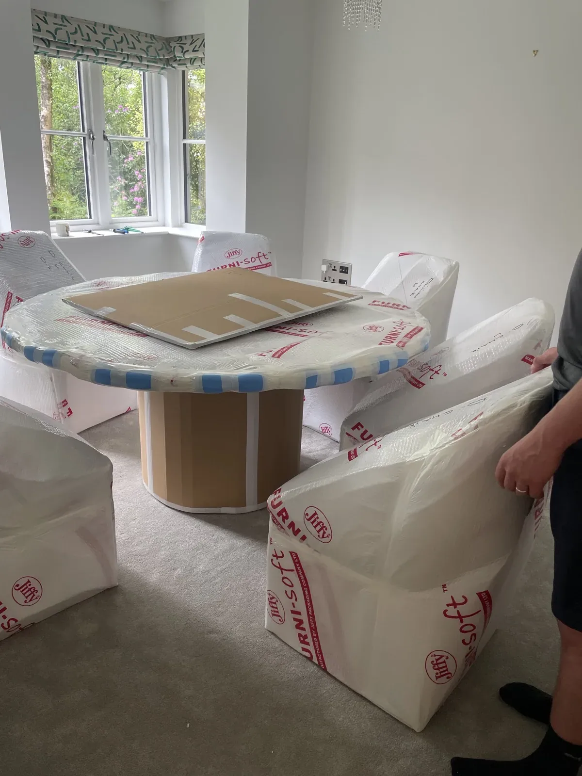Wrapped dining table and chairs on a Surrey house move
