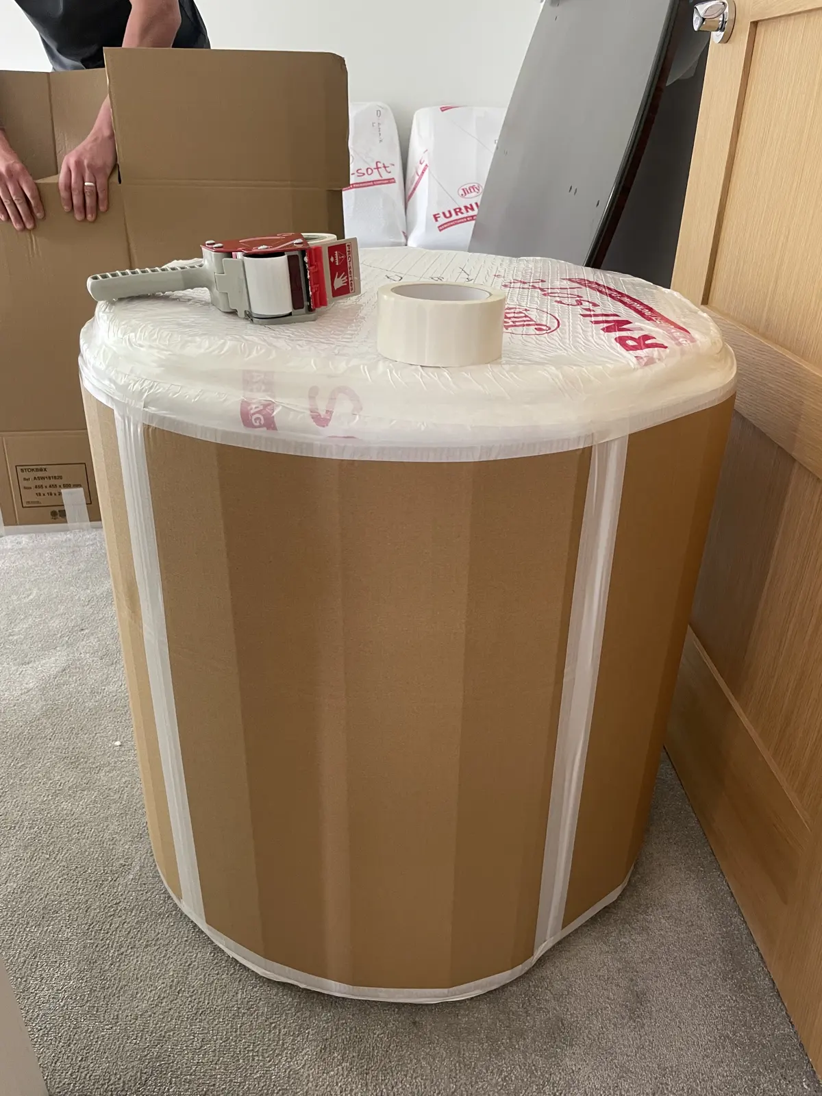 Large round table wrapped in protective covering