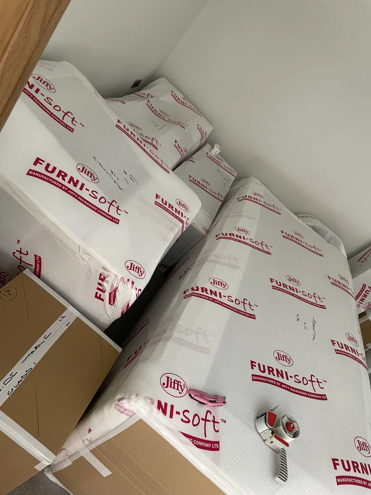 Wrapped sofas stacked in protective covering