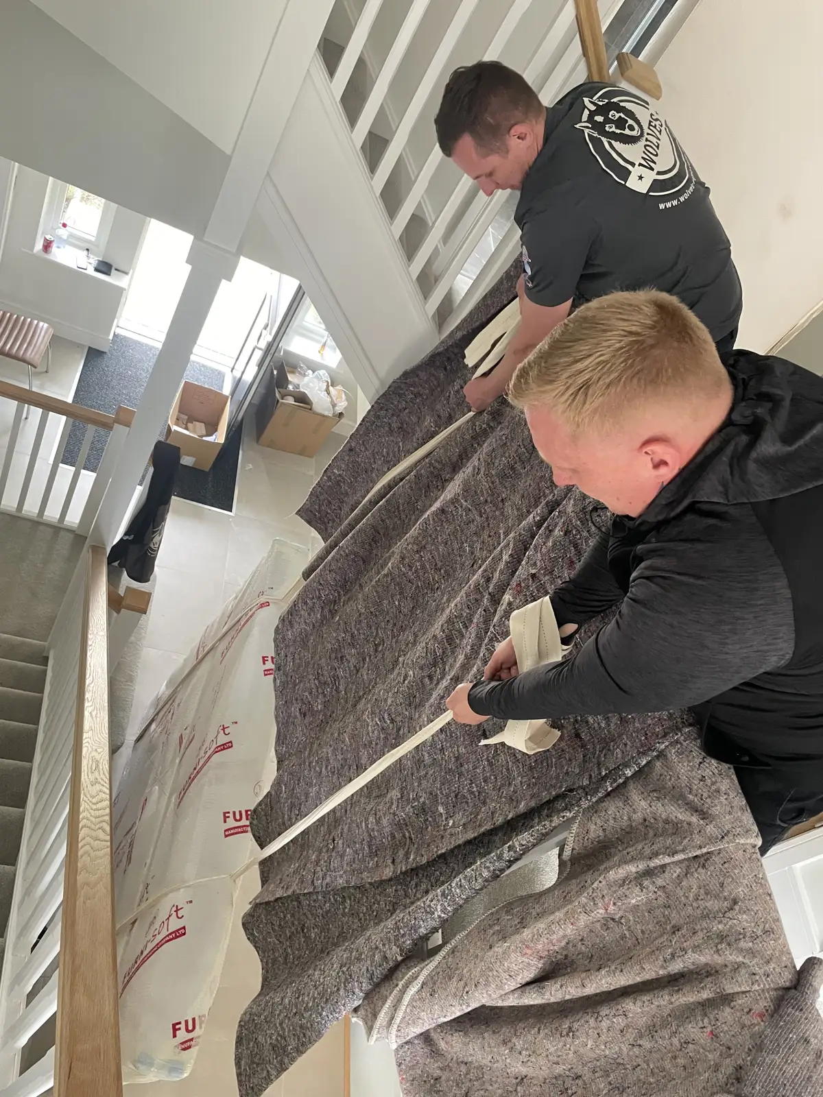 Wrapping a large item on the stairs for a move in Redhill, Surrey